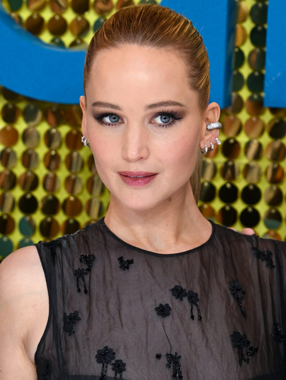 Jennifer Lawrence styled her hair in a sleek ponytail to show off her flawless beauty look and diamond jewelry