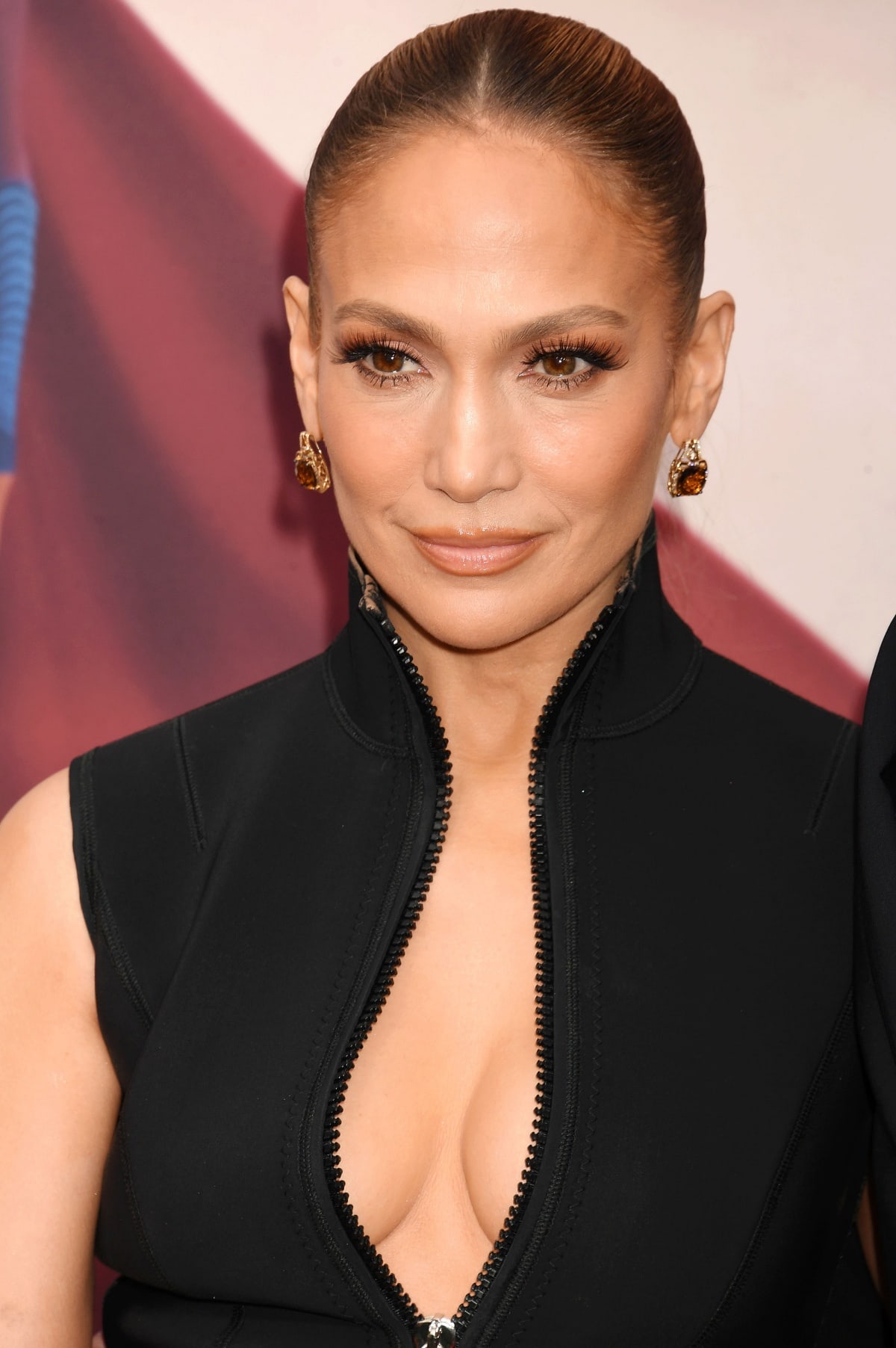 Jennifer Lopez showing off her flawless beauty look, diamond drop earrings, and decolletage in her plunging Gucci wetsuit-inspired dress
