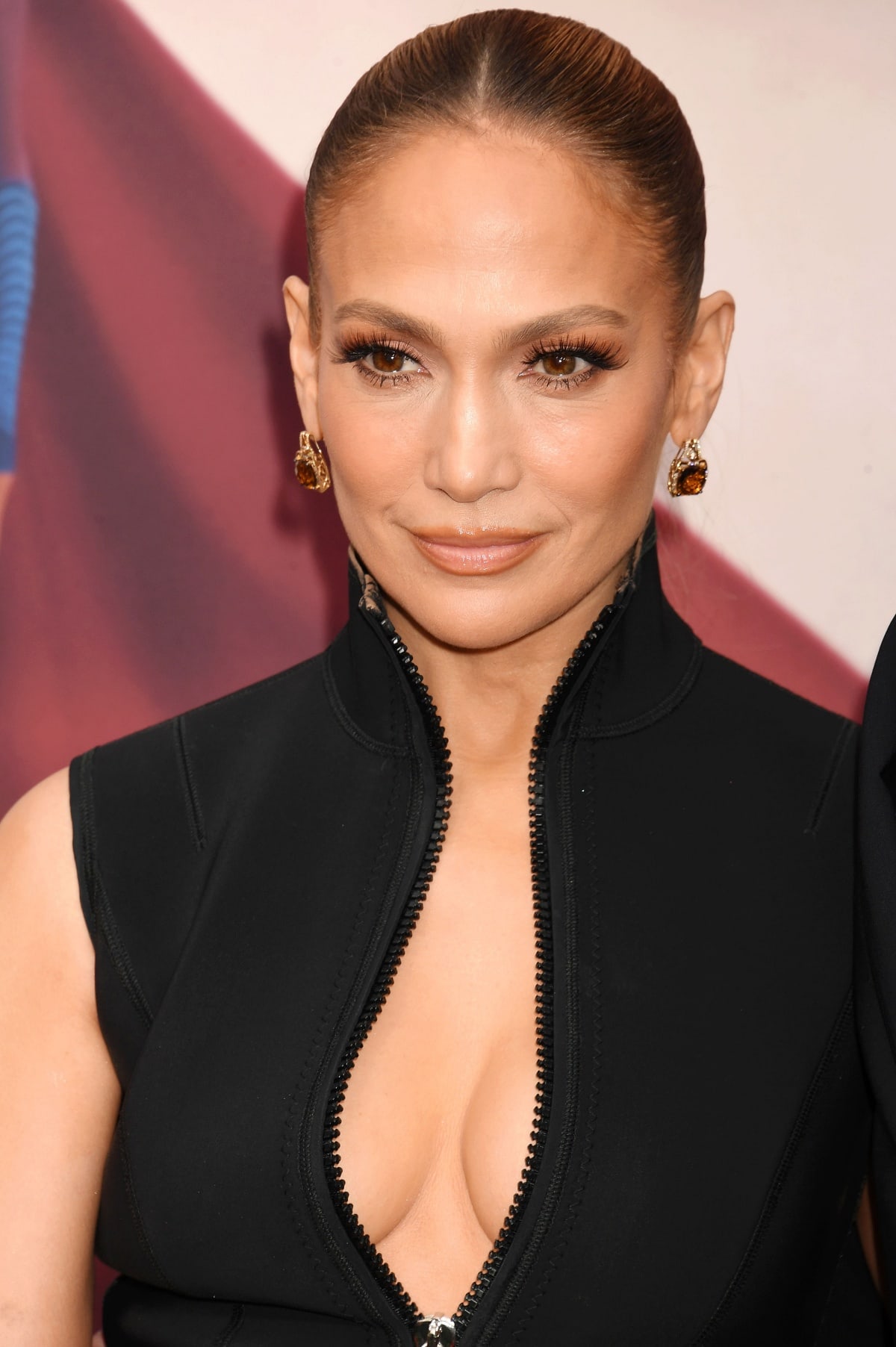 Jennifer Lopez showing off her flawless beauty look, diamond drop earrings, and decolletage in her plunging Gucci wetsuit-inspired dress