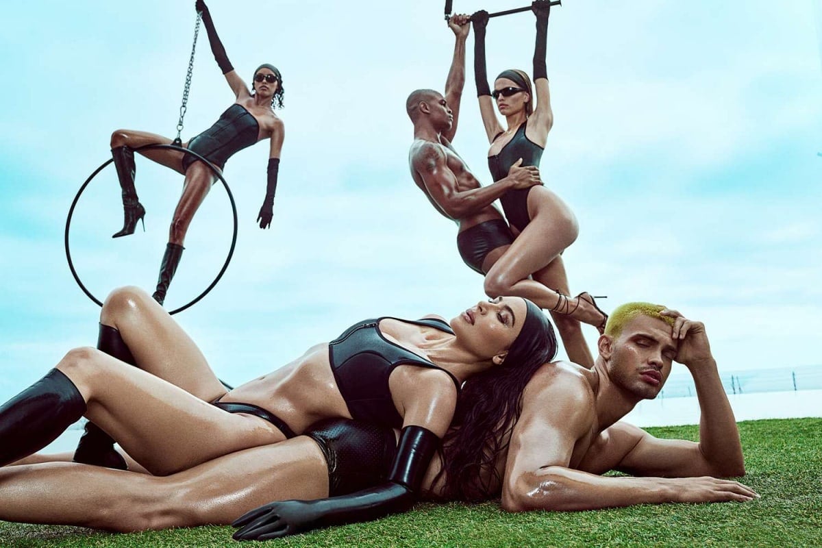 Kim Kardashian surrounded by models in all-black ensembles from the new swimwear line
