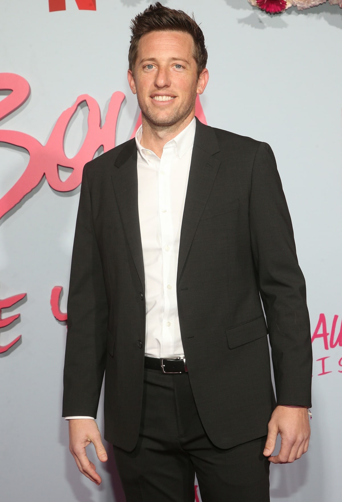 Matt Kaplan wearing a black suit with a white dress shirt at the premiere of To All the Boys: P.S. I Love You