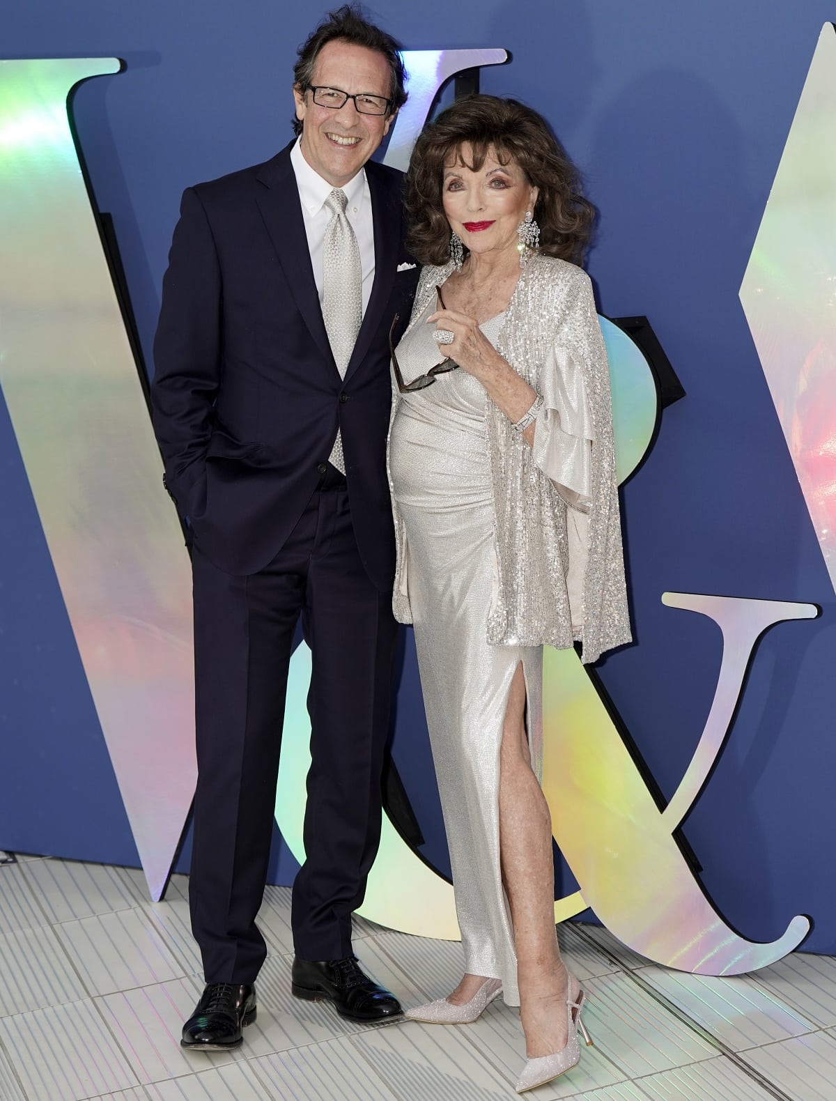 Percy Gibson and Dame Joan Collins posing together for photos at the V&A Summer Party and DIVA Exhibition Preview