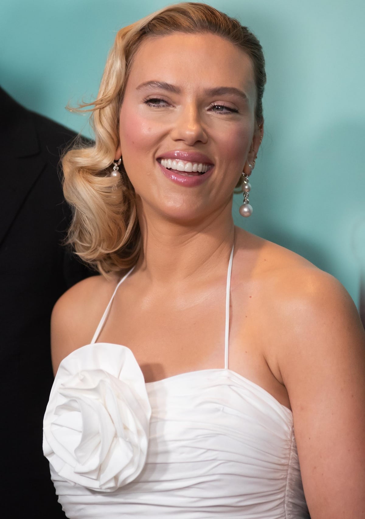 Scarlett Johansson’s beauty look includes flawless makeup, a retro-inspired hairstyle, and David Yurman diamond and pearl earrings for more touches of glamour