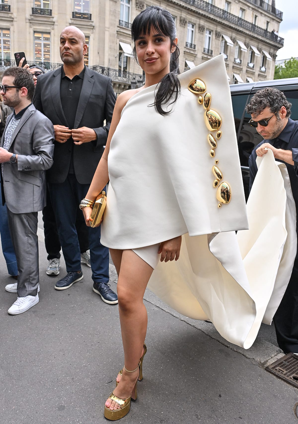 Camila Cabello is the epitome of elegance and sophistication in a structured white mini dress with gold stone embellishments and a dramatic train at Stephane Rolland's Paris Fashion Week Haute Couture Fall/Winter 2024 presentation on July 4, 2023