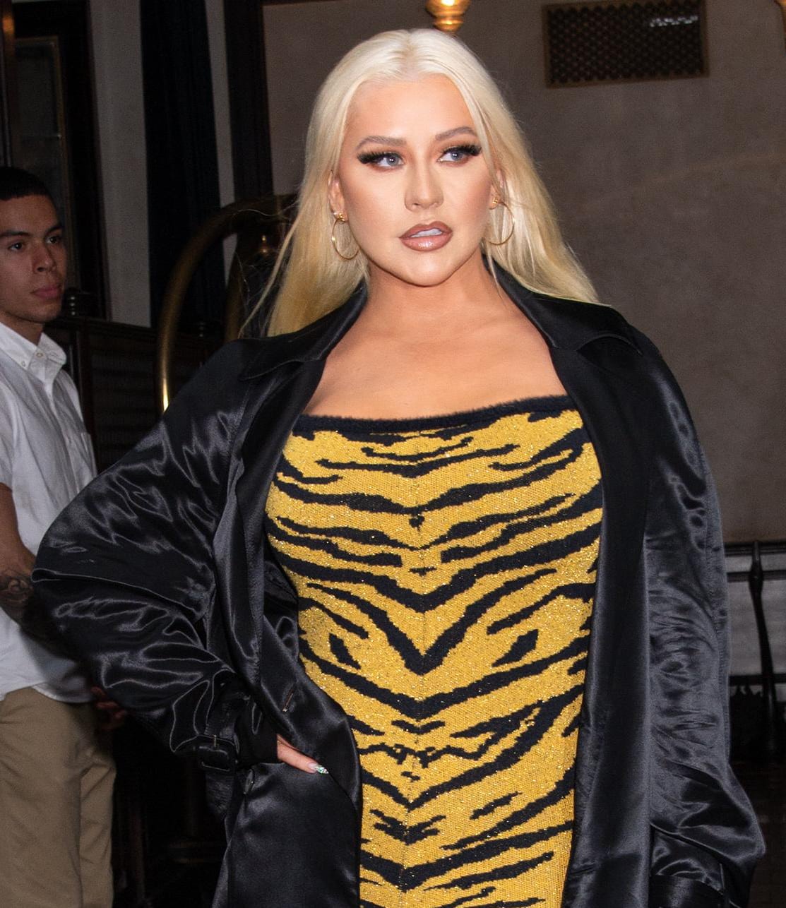 Christina Aguilera wears her mane down and opts for bold makeup with fake eyelashes, smokey eyes, and two-tone nude lips