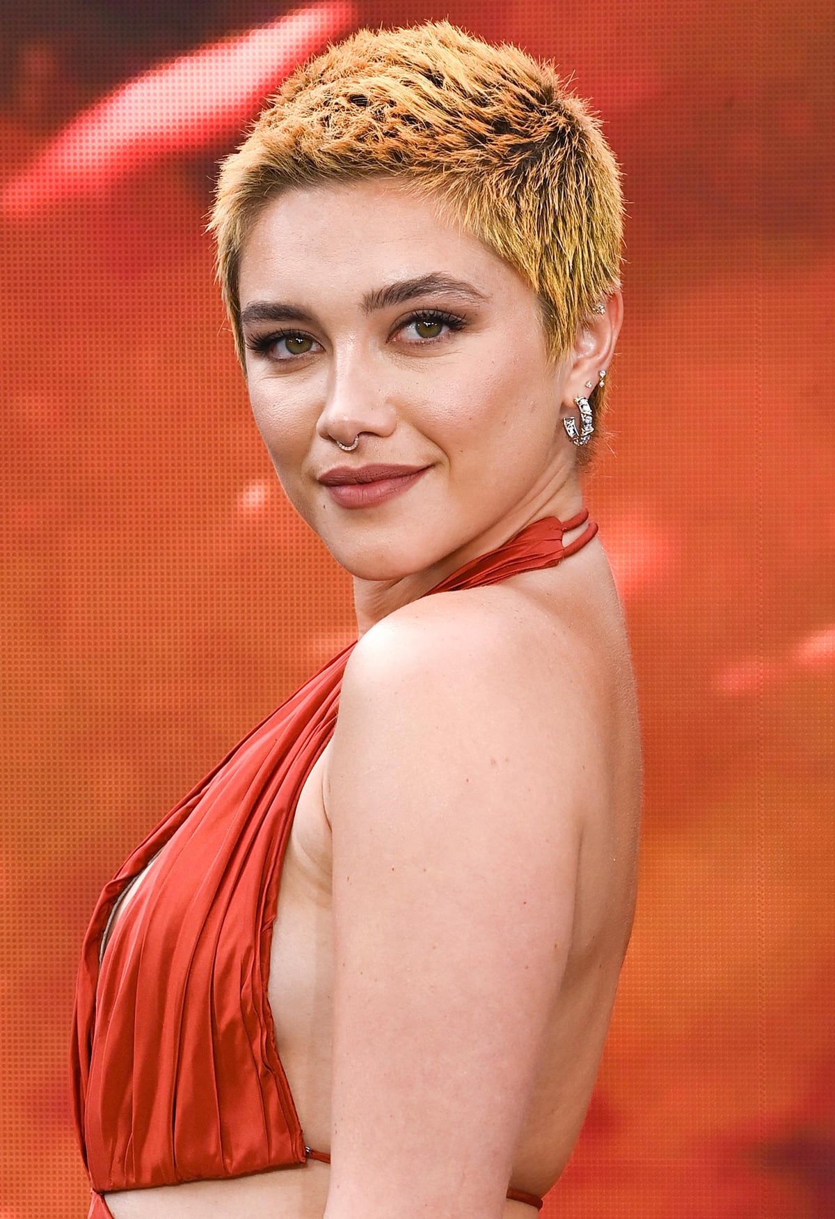 Florence Pugh dyes her edgy buzz cut two-toned orange and wears a warm makeup palette to match her gown