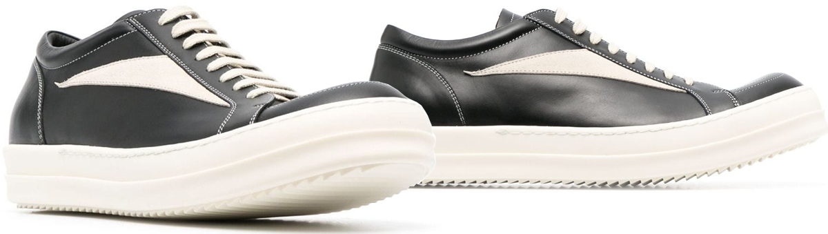 A vintage-style low-top sneaker made of jet black and milk white leather with grained texture and contrast stitching