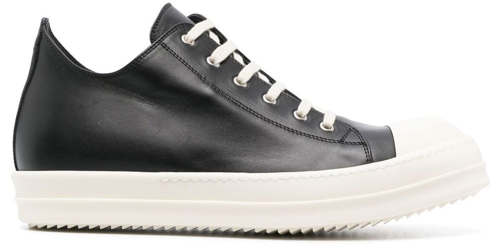 A minimalistic and timeless pair of low-top sneakers made of black leather with round rubber toe caps