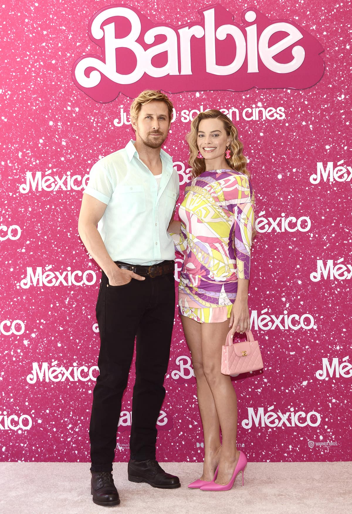 Margot Robbie is joined on the pink carpet by co-star Ryan Gosling, who dresses as his character Ken in a pale green shirt, black pants, and brown shoes