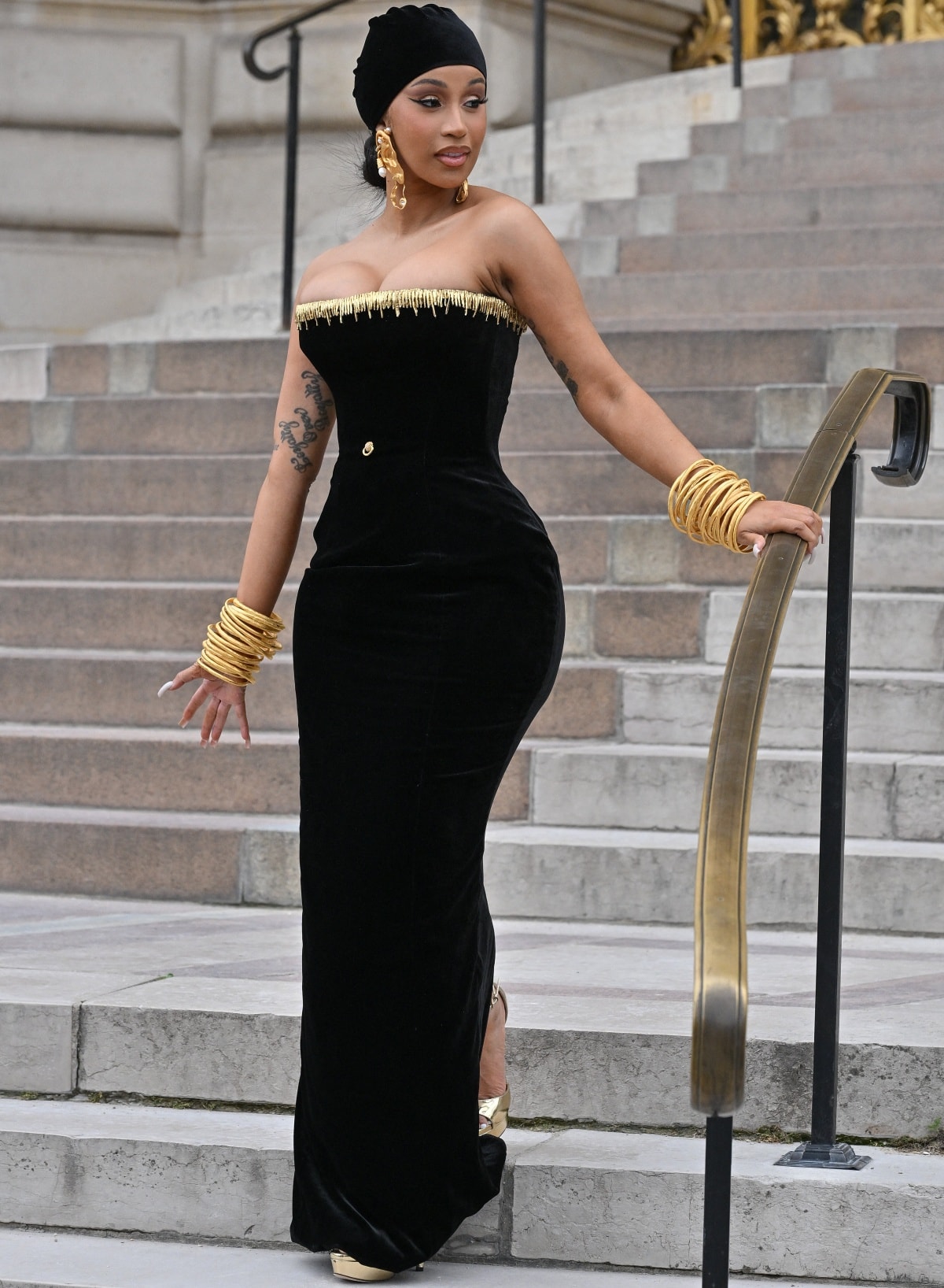 Cardi B removed her feathered bolero to reveal a strapless dress that emphasized her curves