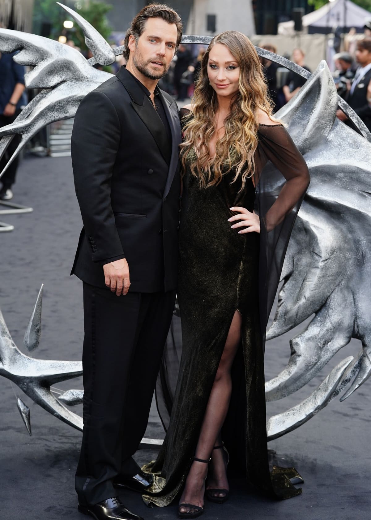 Not to be outdone, Natalie Viscuso matched her boyfriend Henry Cavill’s all-black look and added touches of metallic gold plus a plunging neckline and a thigh-high slit for a head-turning entrance