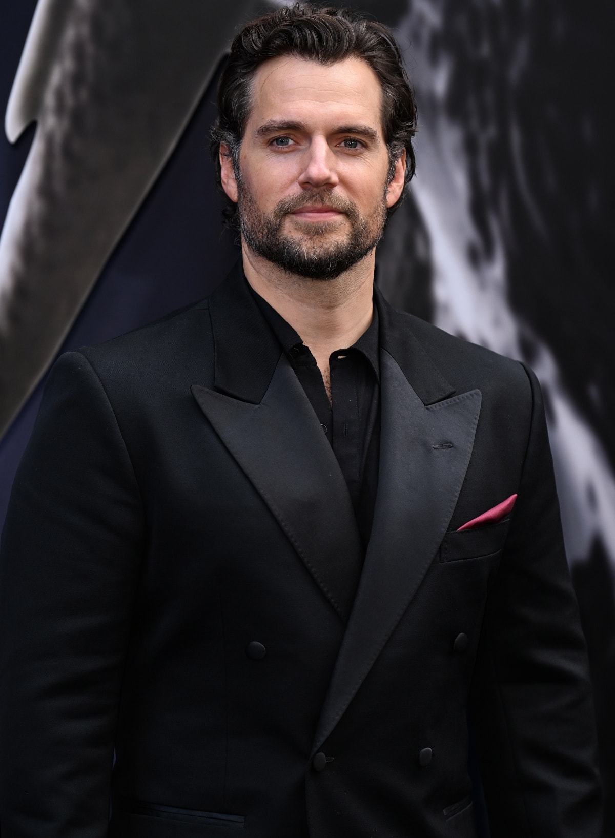 Henry Cavill adding a burgundy satin pocket square for a pop of color to his all-black look