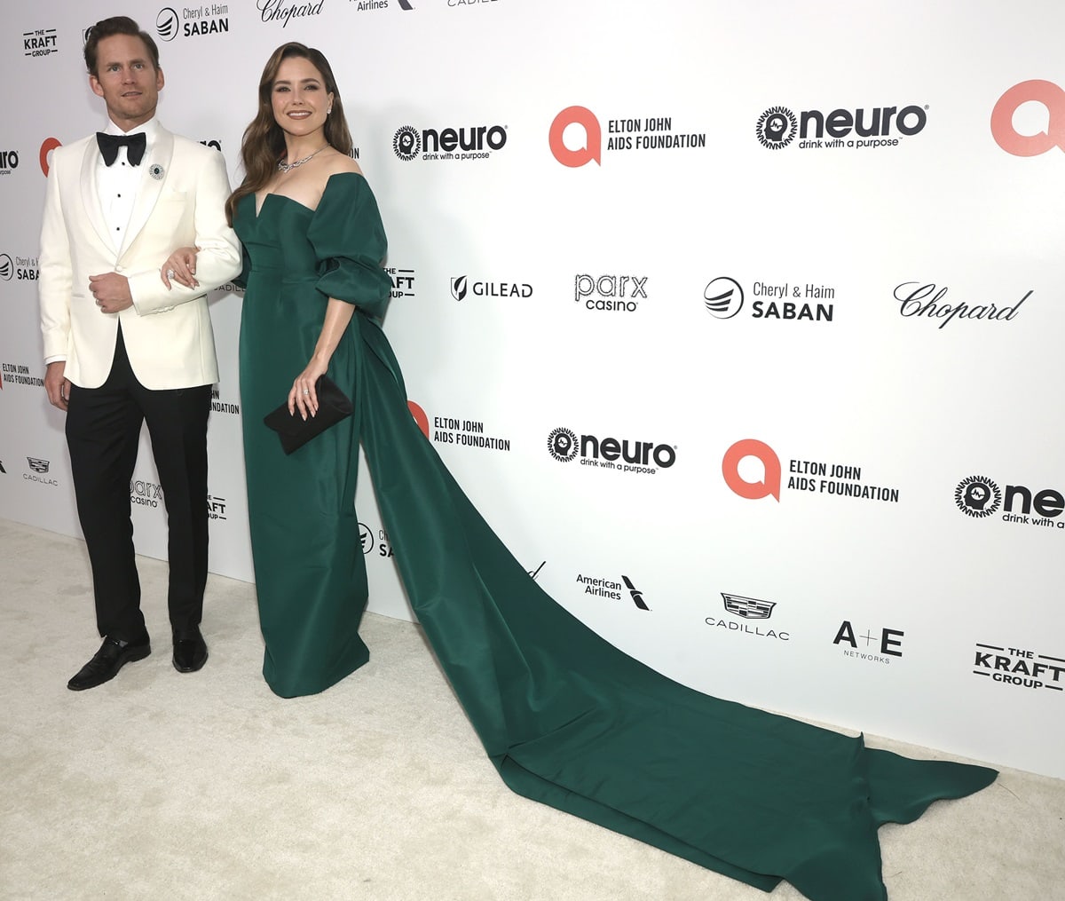 Grant Hughes and Sophia Bush, in an exquisite pine green Andrew Kwon gown featuring charming puff sleeves and a flattering V neckline, attend the Elton John AIDS Foundation's 31st Annual Academy Awards Viewing Party