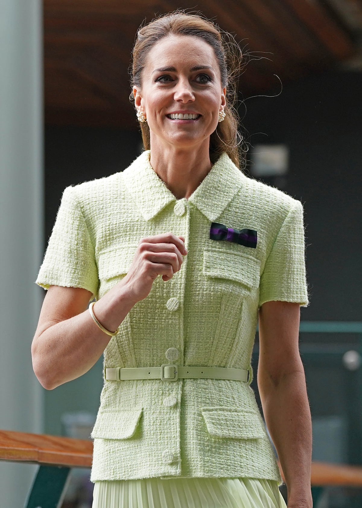 Kate Middleton, the patron of All England Lawn Tennis and Croquet Club, wears a bow pin in dark green and purple colors representing the AELTC