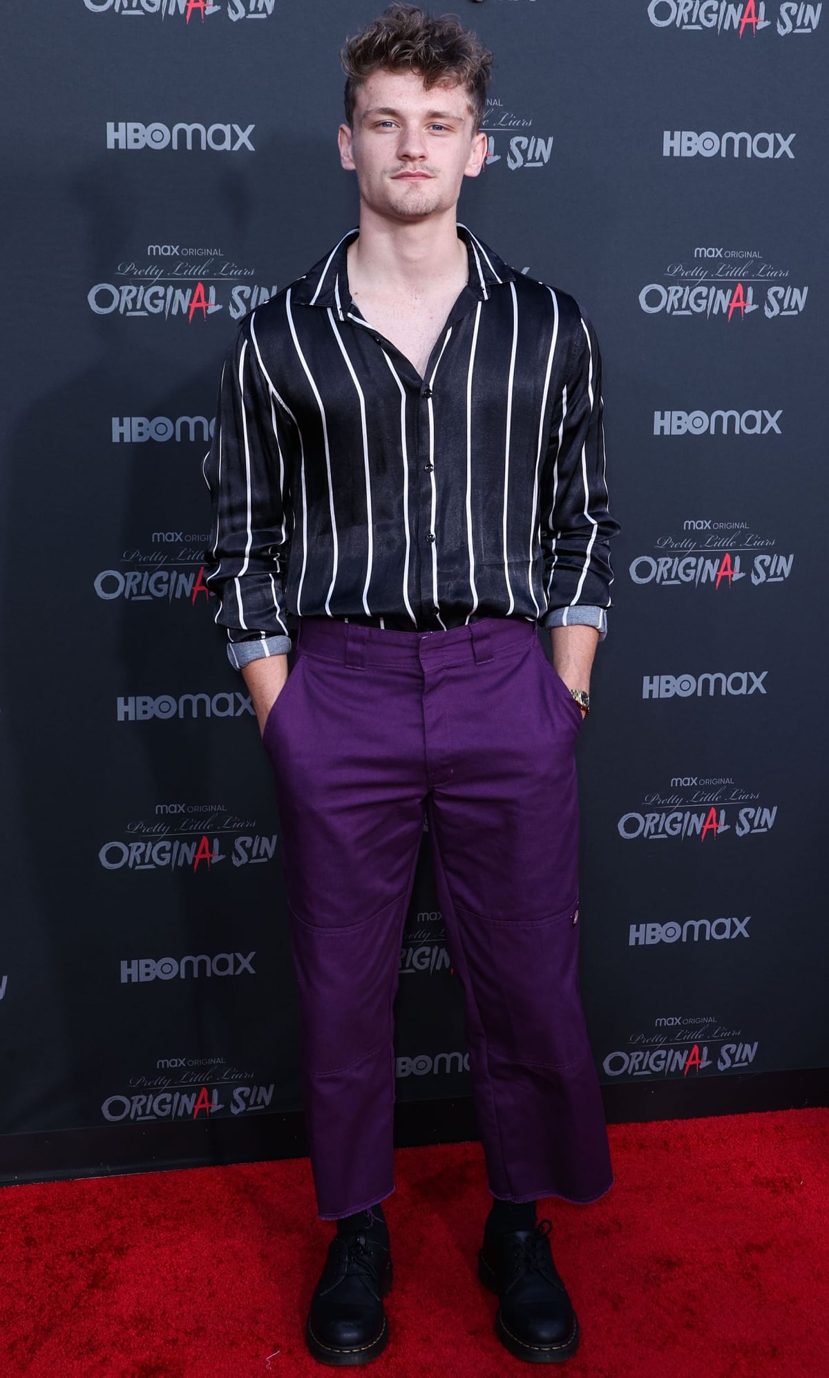 Ben Cook made a bold style statement at the Pretty Little Liars: Original Sin premiere in a striped satin shirt, purple cropped trousers, and chunky black lace-up shoes