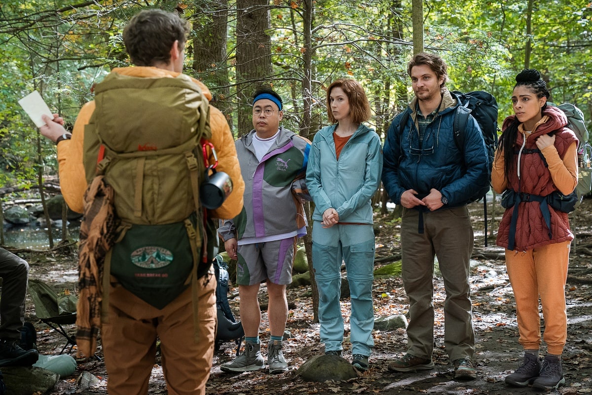 The star of the show, Ellie Kemper, is also the shortest among the main cast members at five feet and five inches, seen here standing between Nico Santos and Luke Grimes in hiking gear on the forest set of Happiness for Beginners