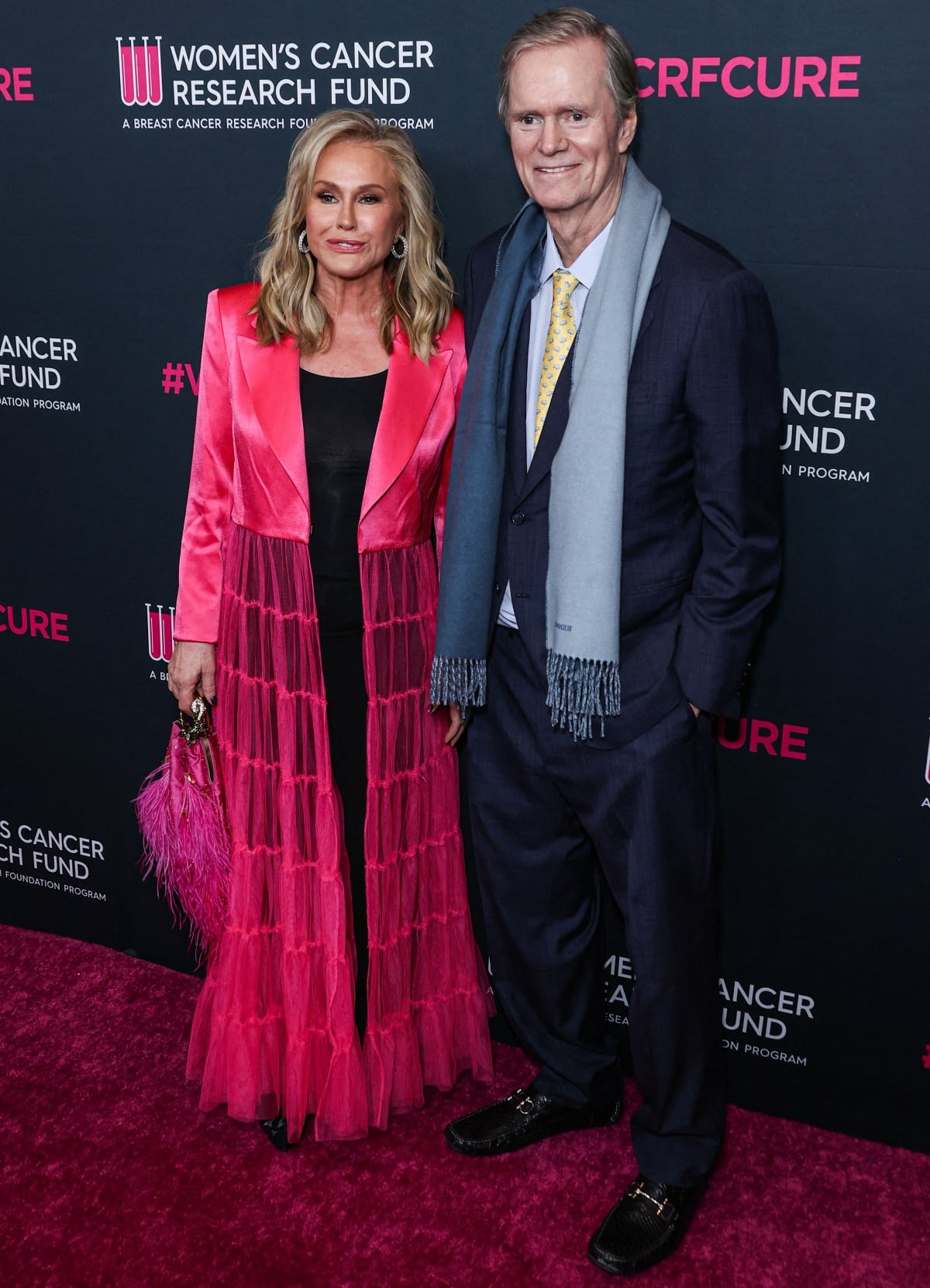Kathy Hilton stuns in a bold pink tulle coat and black heels while Richard Hilton keeps it classic in a navy suit and loafers at the Women’s Cancer Research Fund’s An Unforgettable Evening Benefit Gala 2023 at the Beverly Wilshire in Beverly Hills, California