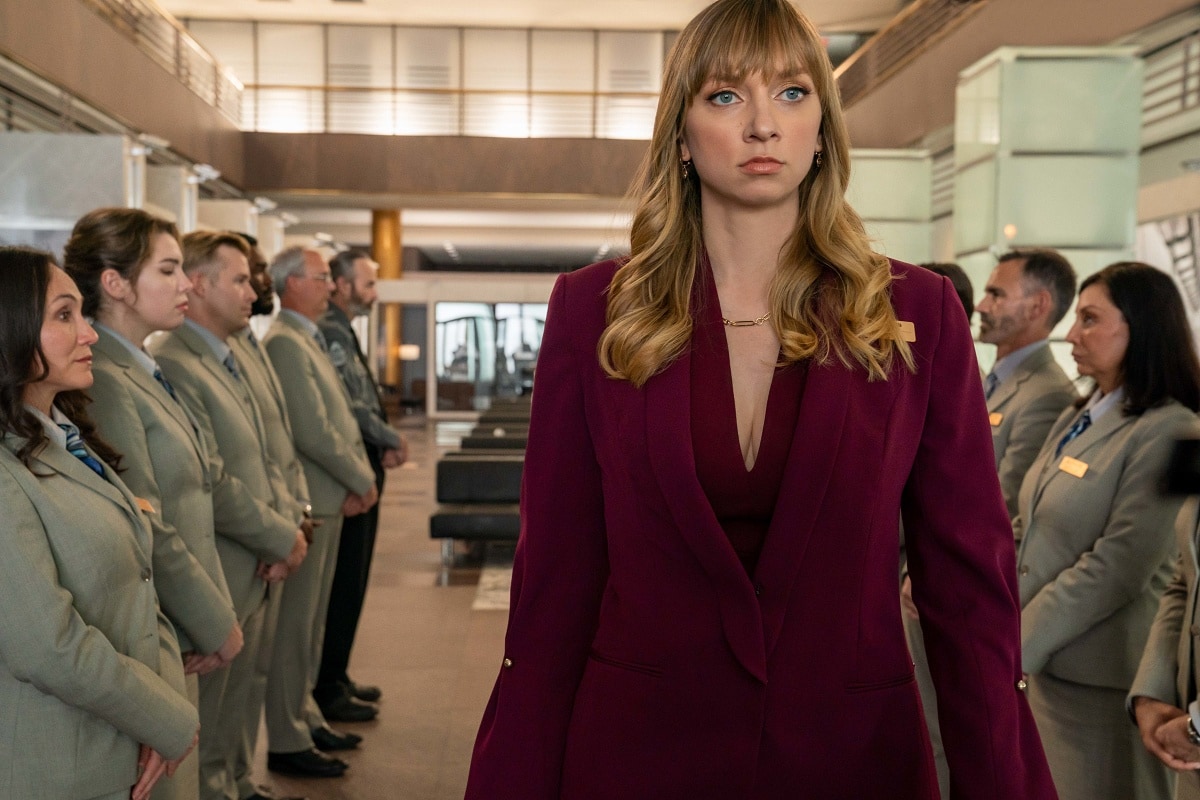Lauren Lapkus commands attention in a deep burgundy suit as she portrays Phoebe King, a competitive bank manager, in the 2023 action-comedy The Out-Laws