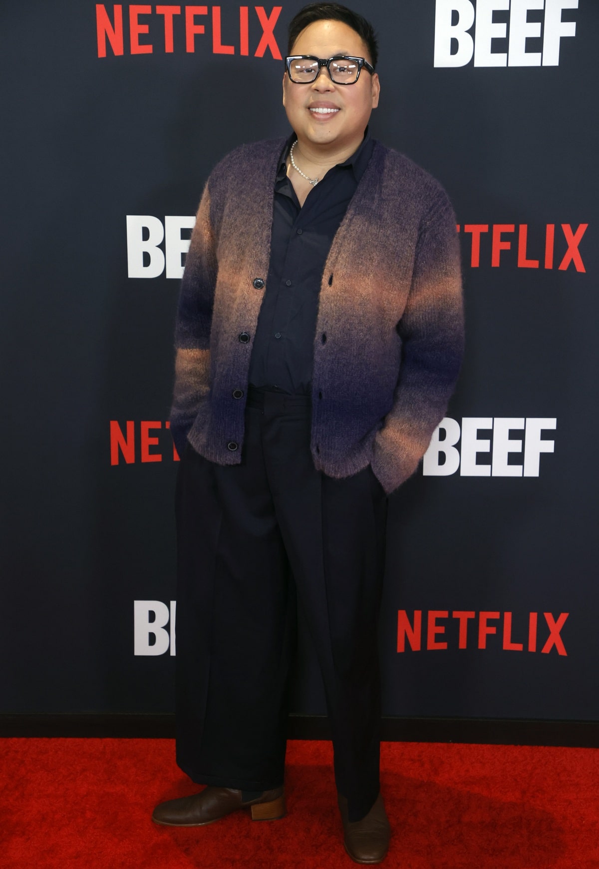 Nico Santos brought cozy-chic vibes to the Beef premiere in a gradient knit cardigan, wide-leg trousers, and brown square-toe heeled boots that added a stylish lift