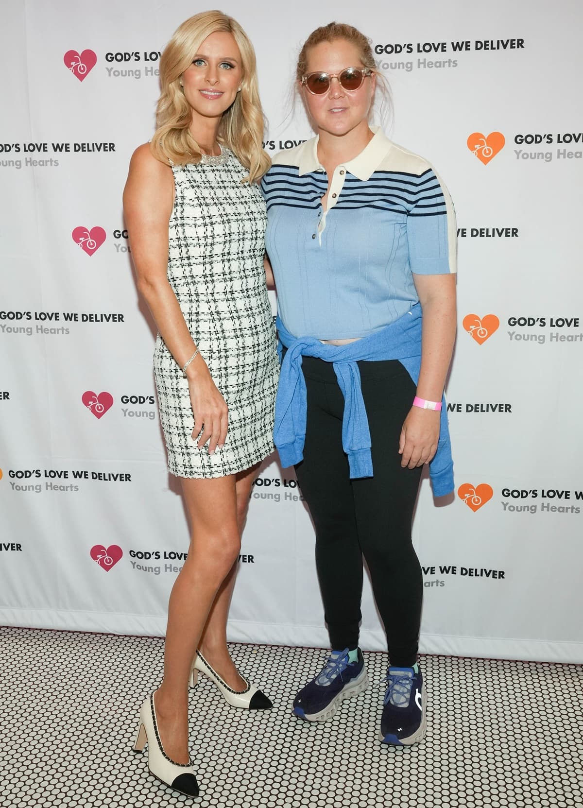 Nicky Rothschild and Amy Schumer embraced contrasting styles at God's Love We Deliver event, with Nicky looking chic in a tweed mini dress and pointed heels, while Amy kept it casual in athleisure wear and sneakers
