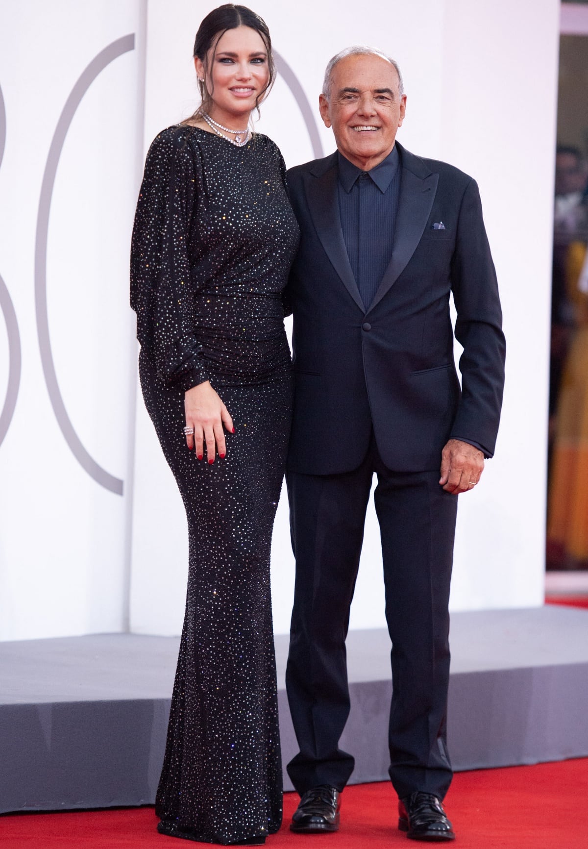 Adriana Lima posing for photographs with Alberto Barbera on the red carpet during the 80th Venice International Film Festival