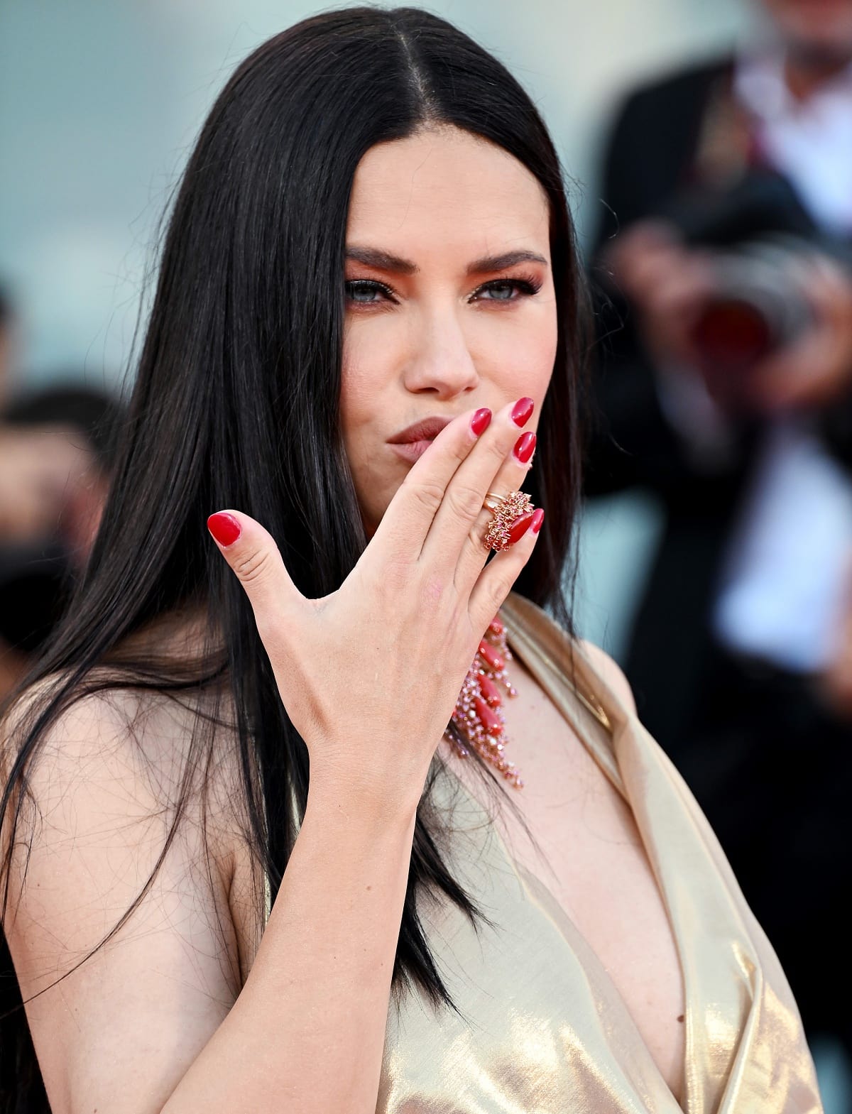 Adriana Lima showing off her large red ring, which matched her eye-catching diamond necklace and sultry red nails