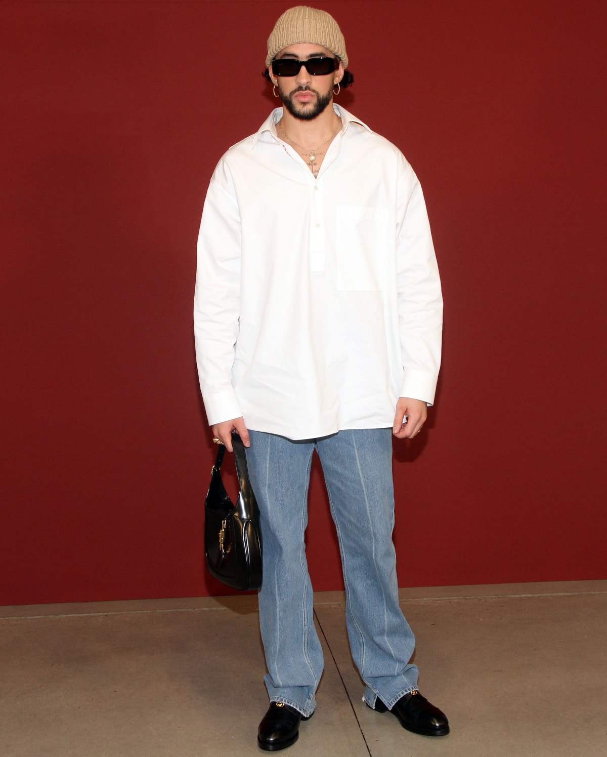 Bad Bunny in a casual-cool ensemble with a crisp white button-down shirt and classic blue straight-leg jeans