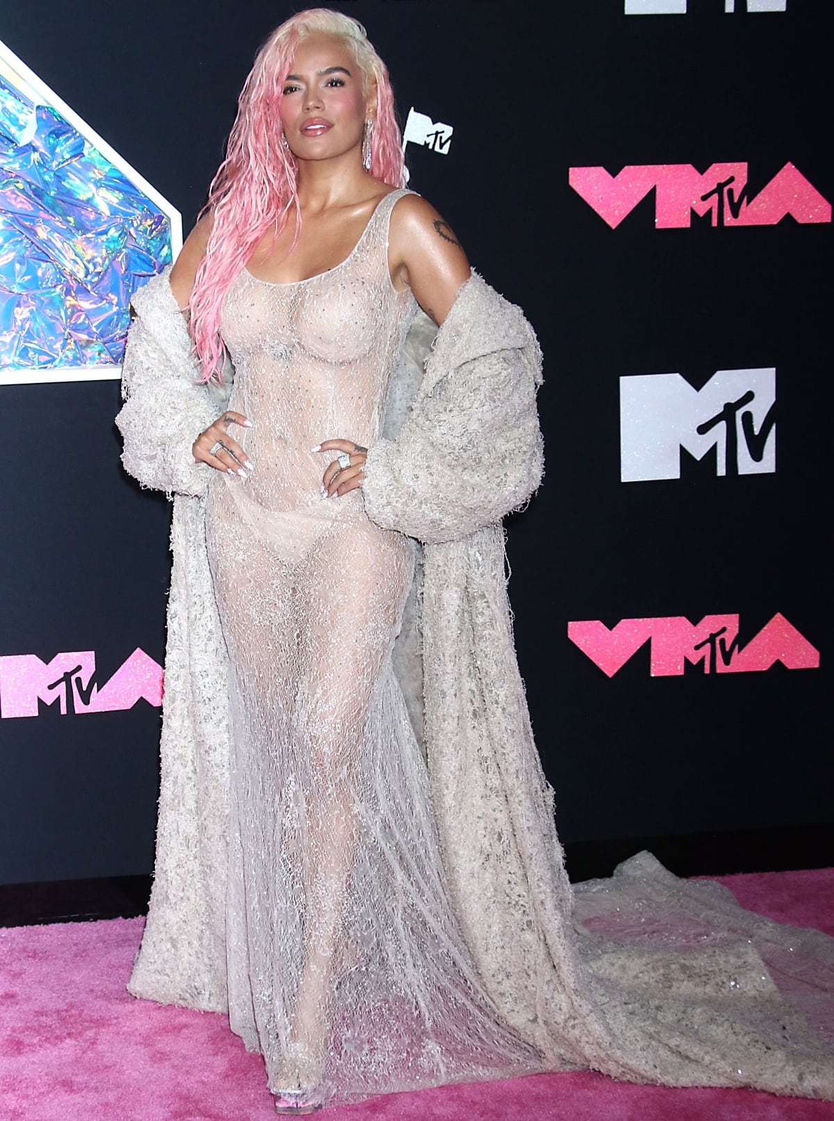 Karol G making a head-turning entrance in a sheer nude lace gown from Ashi Studio’s Fall 2023 couture collection at the 2023 MTV Video Music Awards