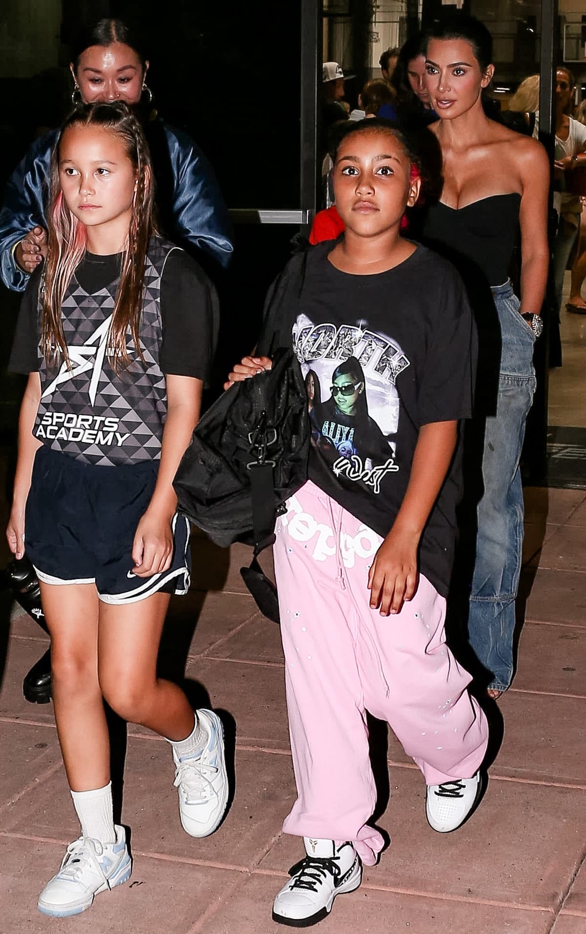North West was photographed wearing a black graphic tee with pink sweatpants and white Nike sneakers