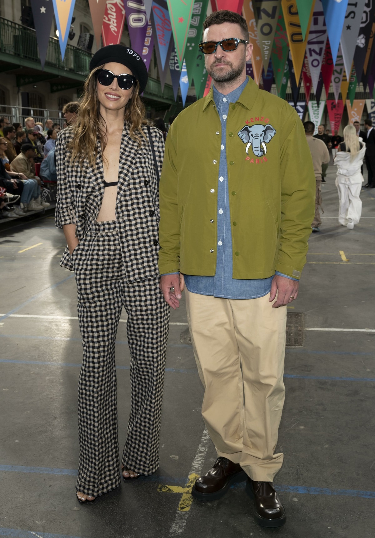 Jessica Biel rocks a chic gingham suit and beret, while Justin Timberlake opts for a casual look in an olive green Kenzo jacket and beige trousers at the Kenzo Menswear Spring/Summer 2023 show during Paris Fashion Week
