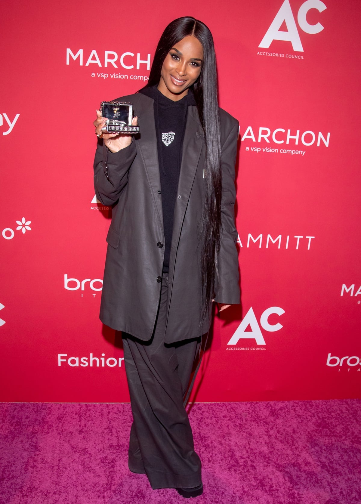 Ciara exudes chic sophistication in an oversized charcoal suit as she proudly holds her award at the 27th annual ACE Awards