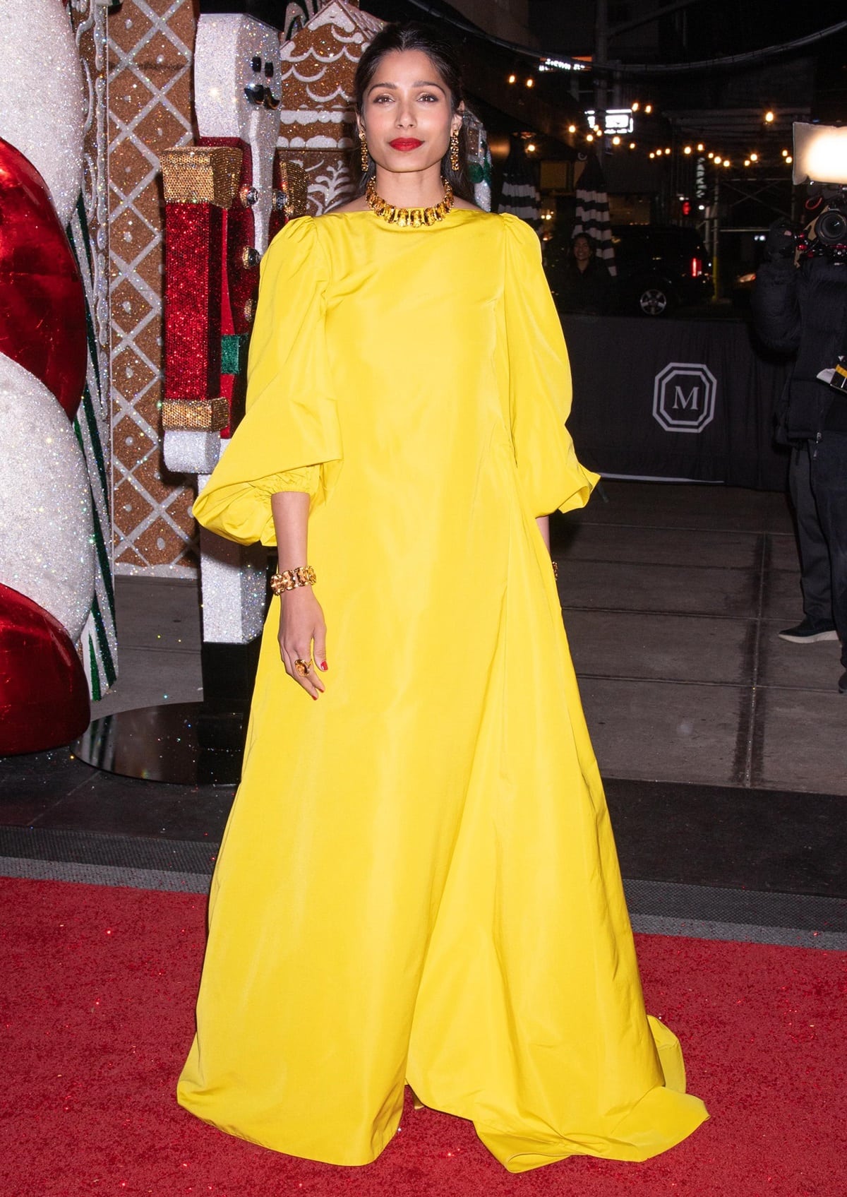 Freida Pinto wears a bold yellow Valentino dress at a Swarovski Holiday event at the Mark Hotel