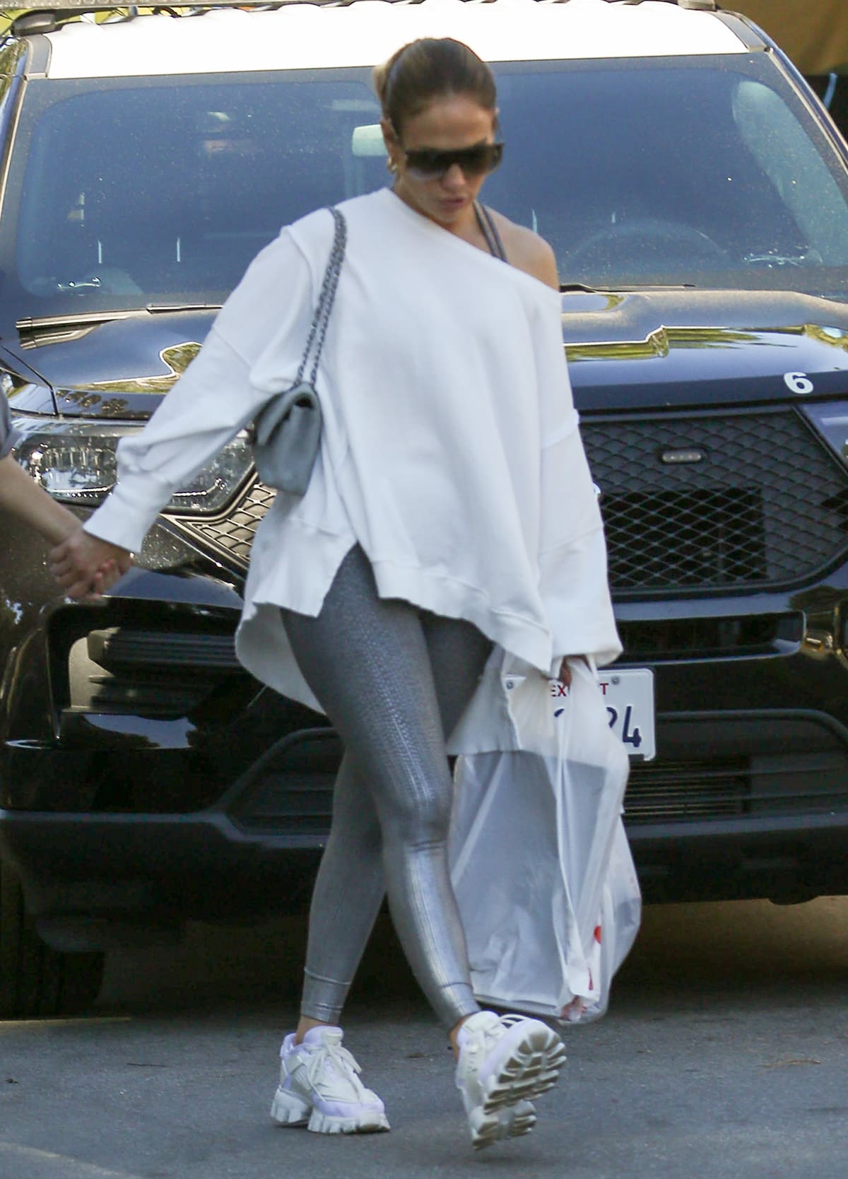 Jennifer Lopez opts for casual-cool style in a Free People sweatshirt with matching Beyond Yoga Drip Drop bra top and leggings