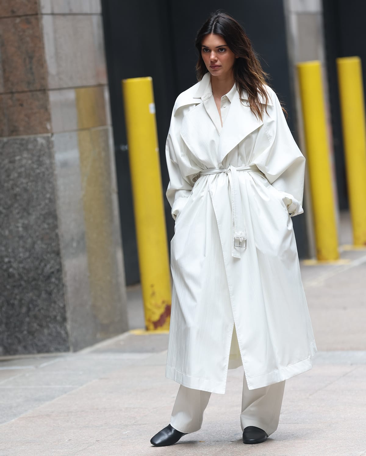 Kendall Jenner looks fresh in a white coat with a flattering tie-waist fastening at the front