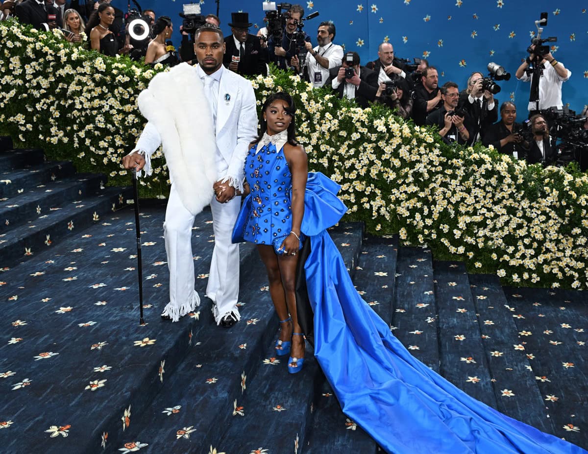 Simone Biles and husband Jonathan Owens turned heads at the 2025 Met Gala, with Biles dazzling in custom bright blue Aquazzura “Yes Darling” platform heels and a dramatic high-low gown, perfectly complementing Owens’ white suit and fur-accented cap