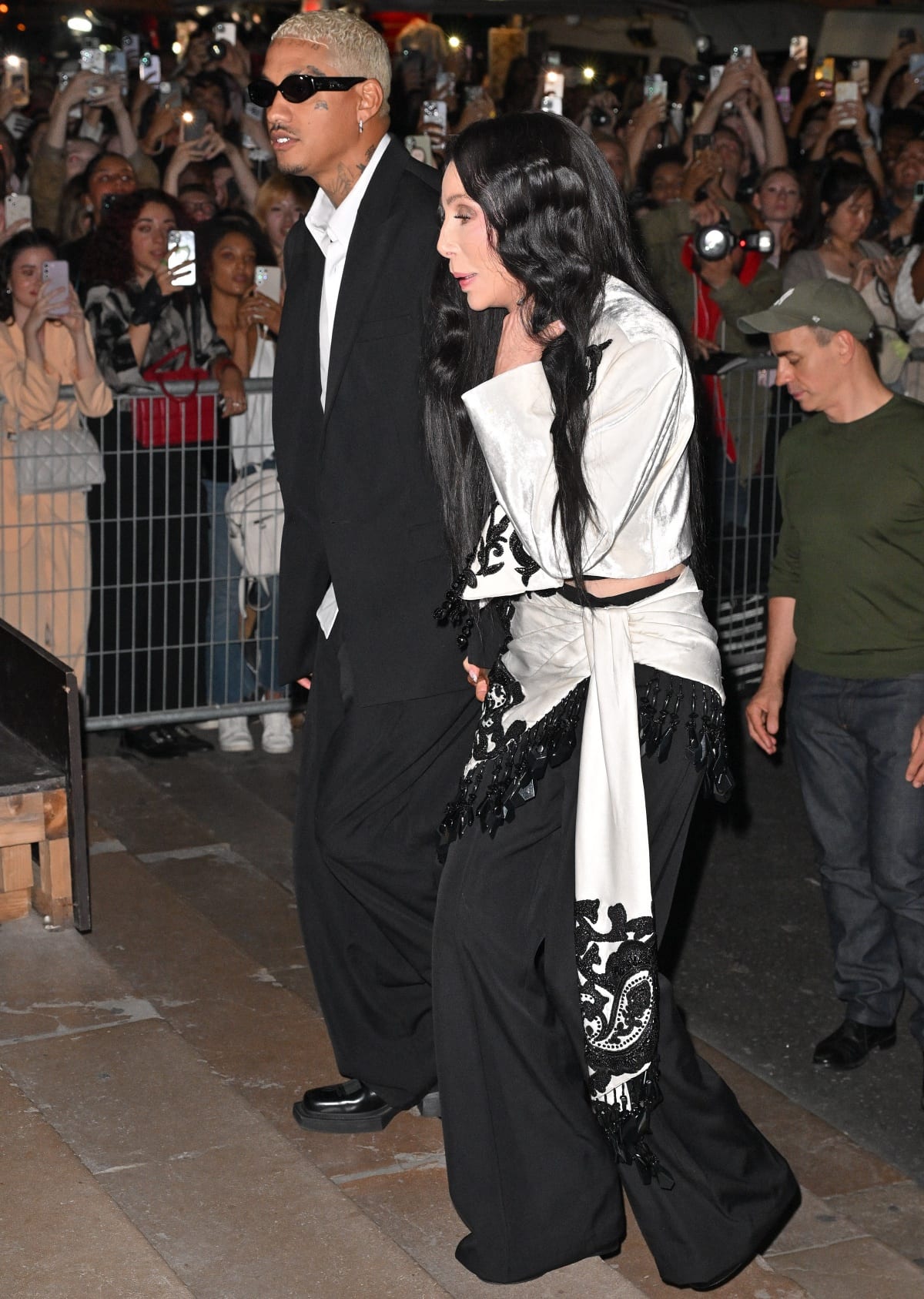 Alexander “AE” Edwards and Cher holding hands as they made their way to their seats in the front row