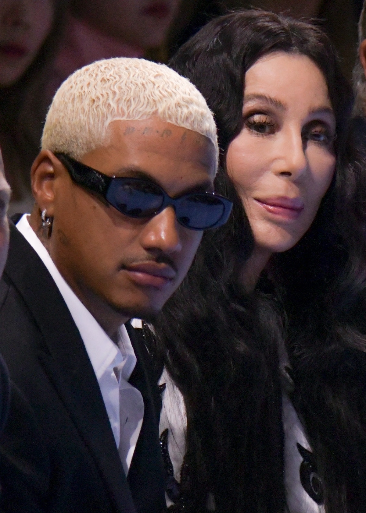 Alexander “AE” Edwards and Cher watching the Balmain Spring/Summer 2024 fashion show in the front row