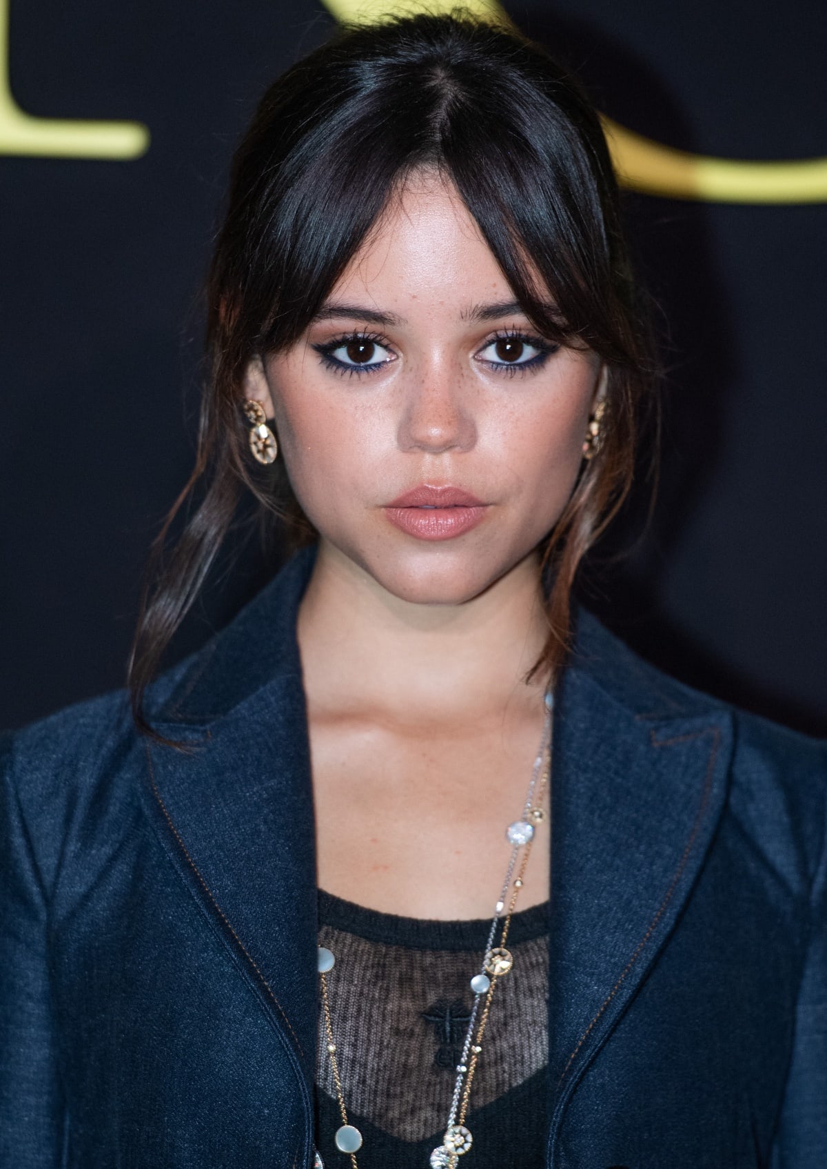 Jenna Ortega’s beauty look consisted of her signature curtain-banged fringe, a peachy-pink lip, and Dior Rose des Vents jewelry