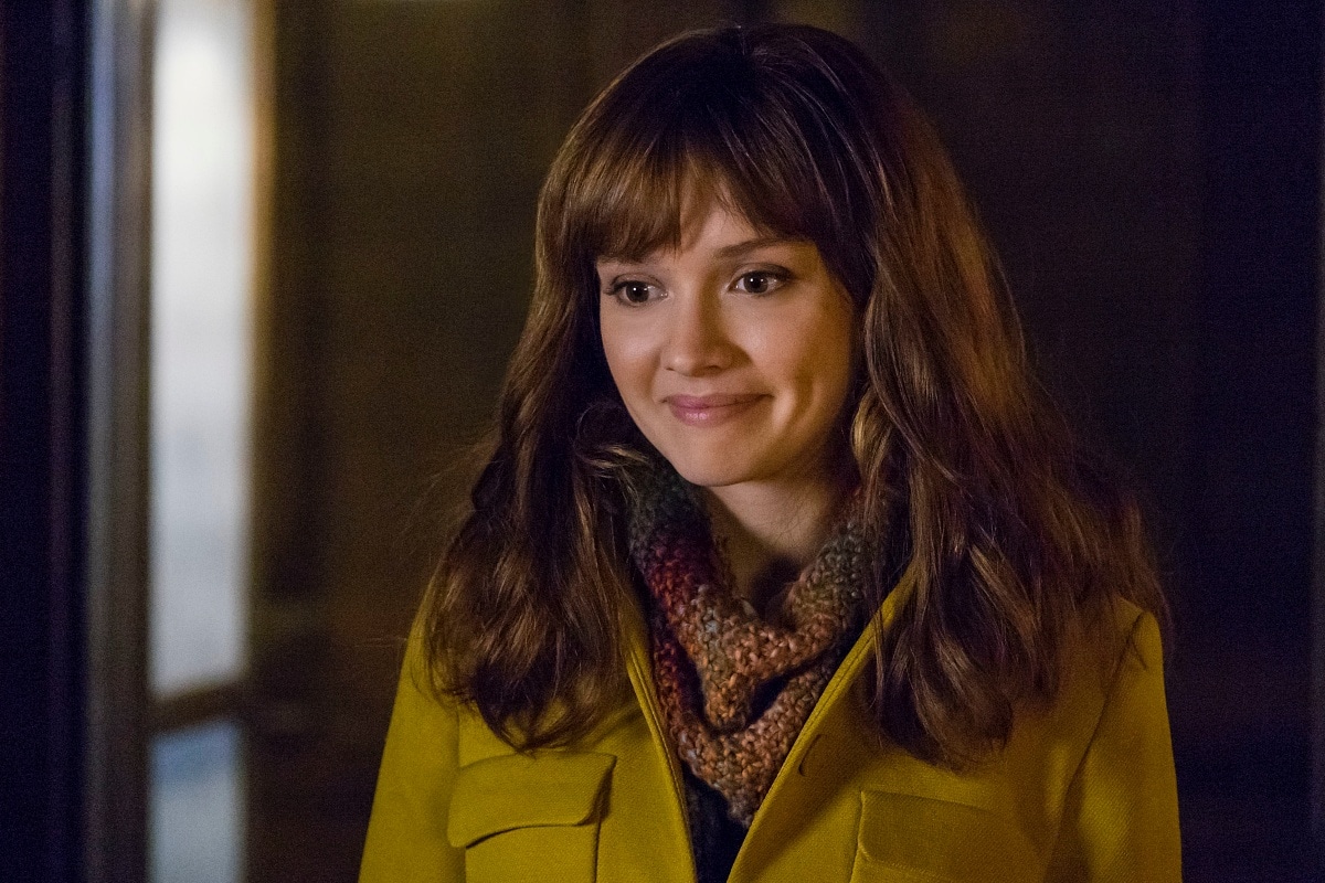Olivia Cooke as Emma Decody in Bates Motel, wearing a mustard yellow coat and multicolored knit scarf — a soft look that contrasts with the series' dark psychological themes