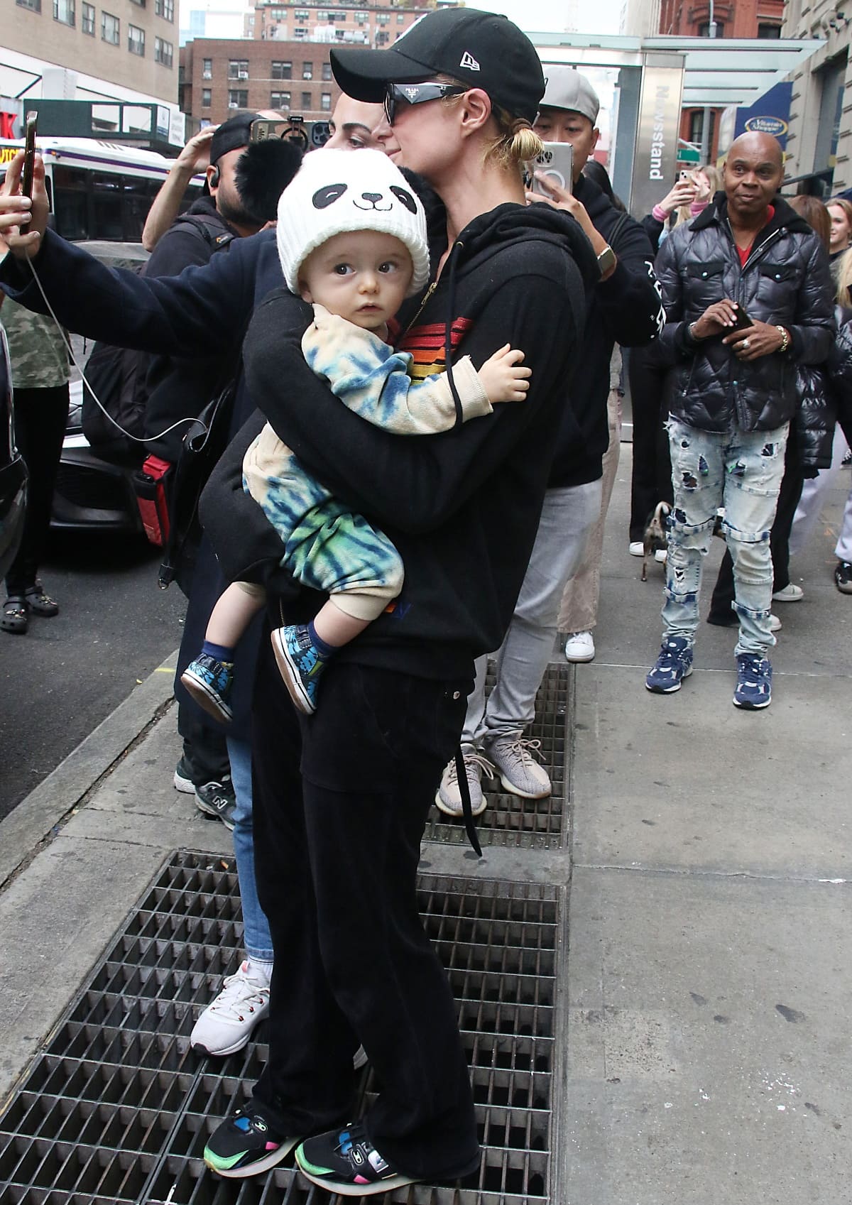 Paris Hilton cradling son Phoenix Barron Hilton Reum and taking selfies with fans while out and about in New York City
