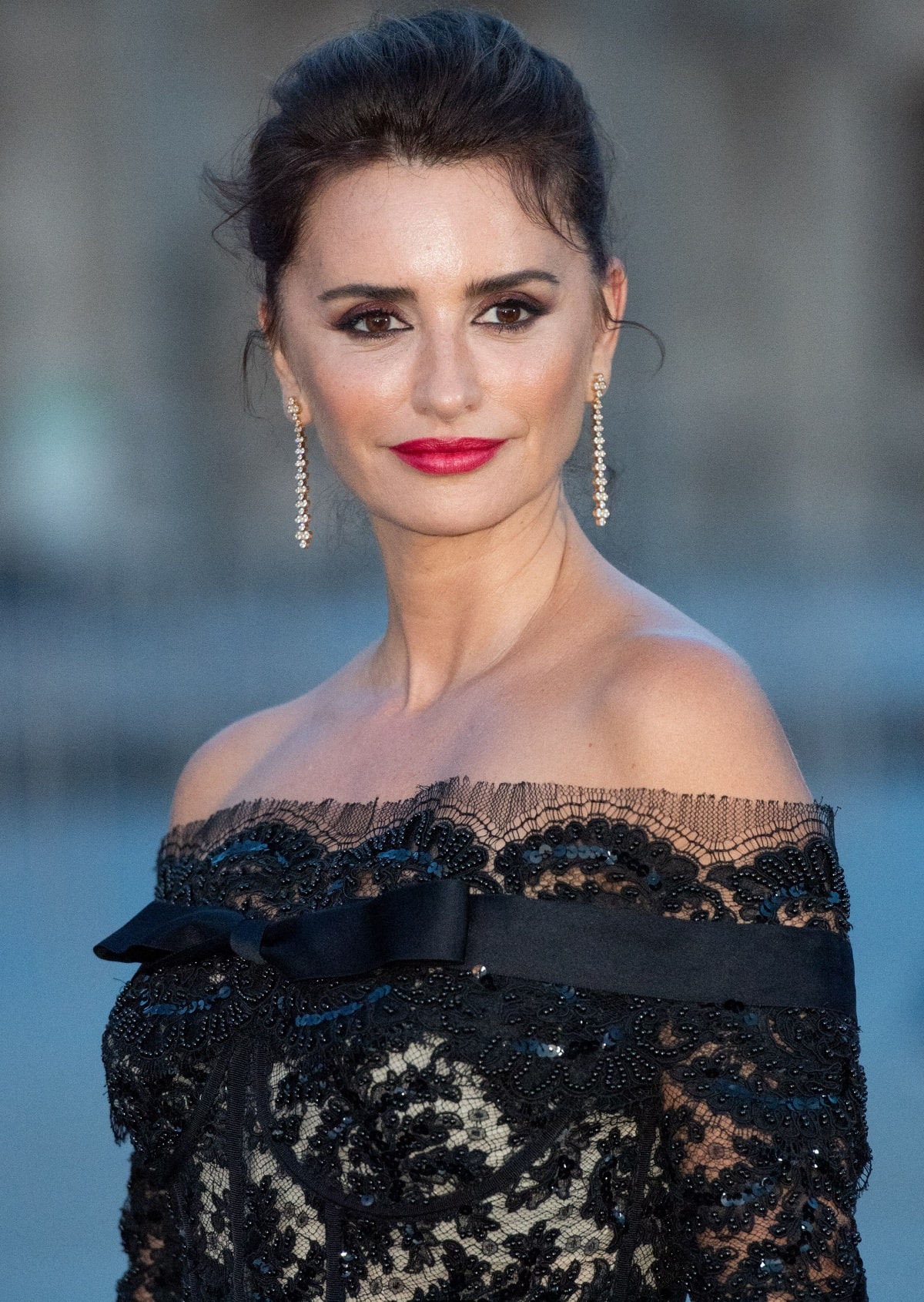 Penélope Cruz’s beauty look consisted of smoky eyes, a bold red lip, an elegant updo, and diamond drop earrings