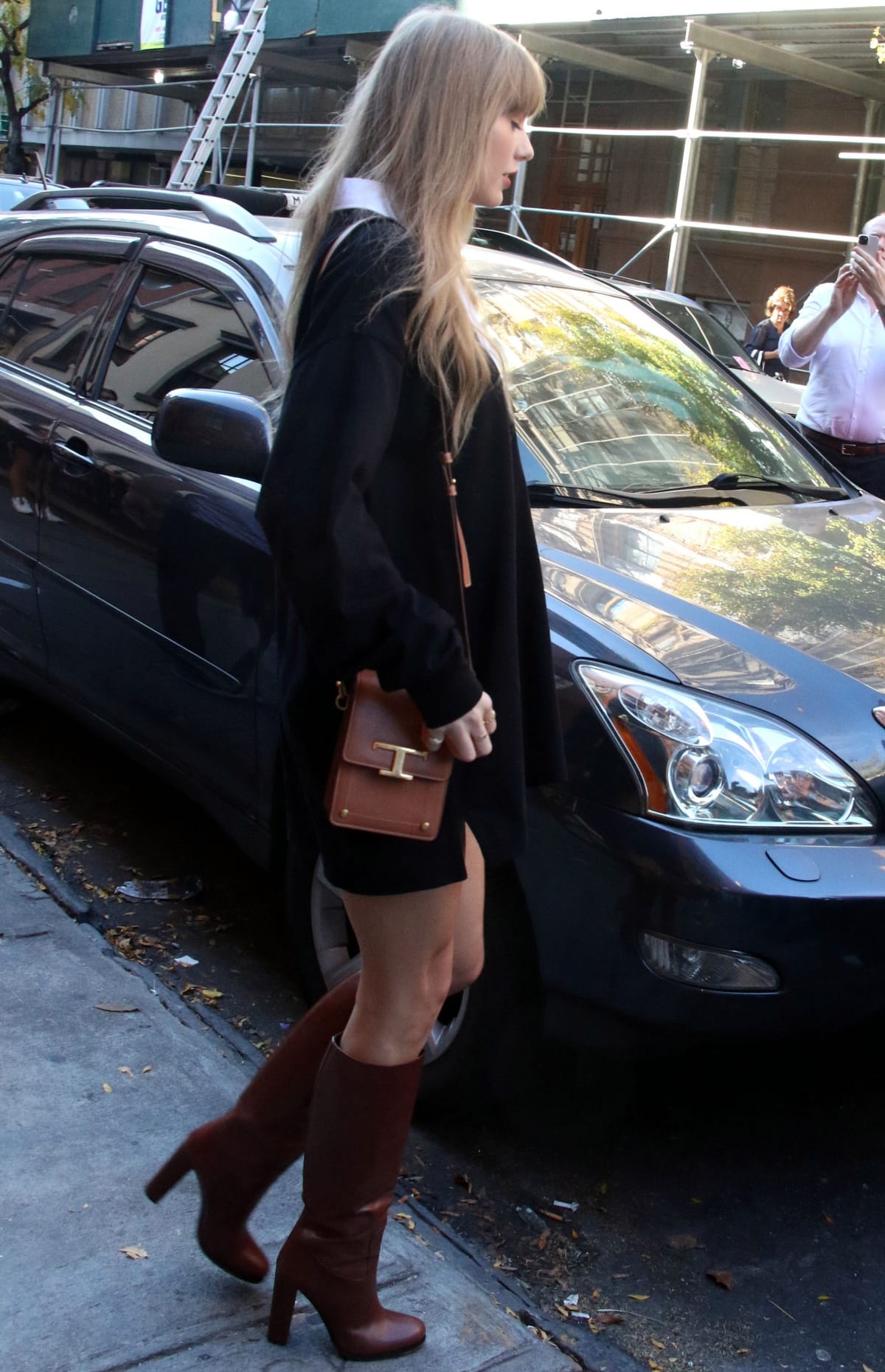 Taylor Swift wearing Stella McCartney oversized rugby shirt with Prada burgundy leather knee-high boots