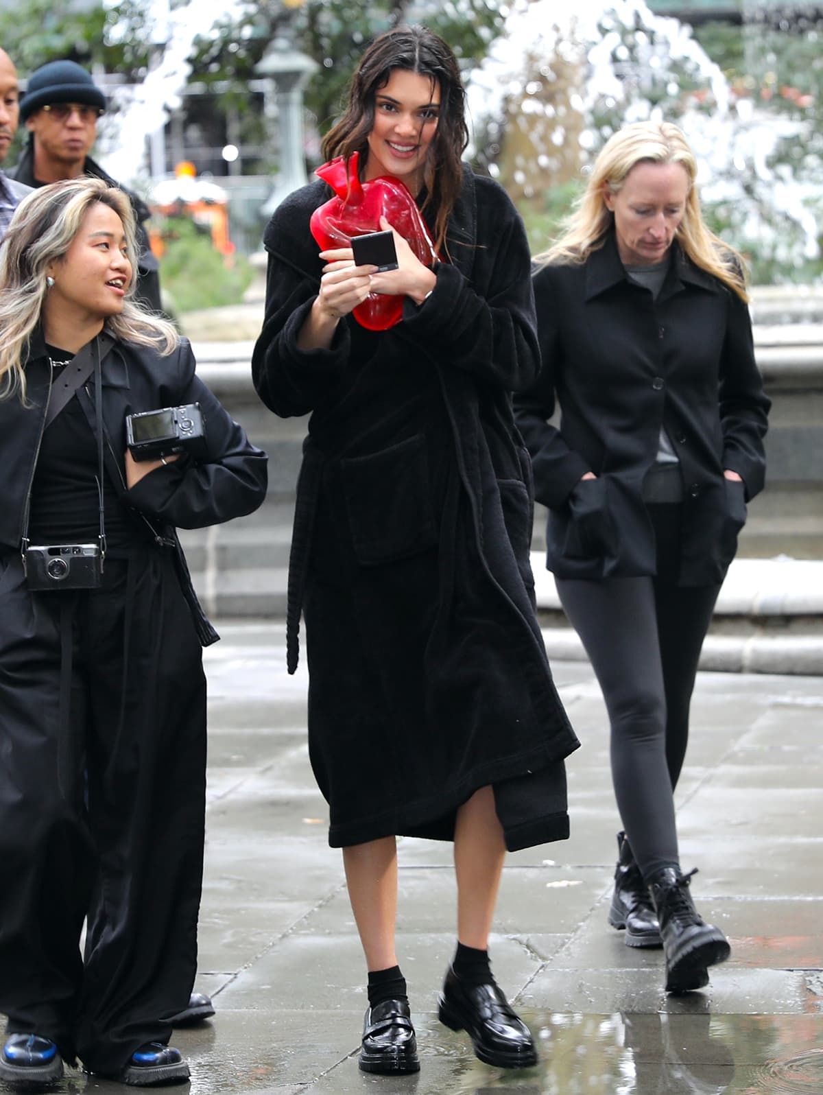 Kendall Jenner wraps up warm in a black robe while still wearing her dripping-wet black socks and loafers