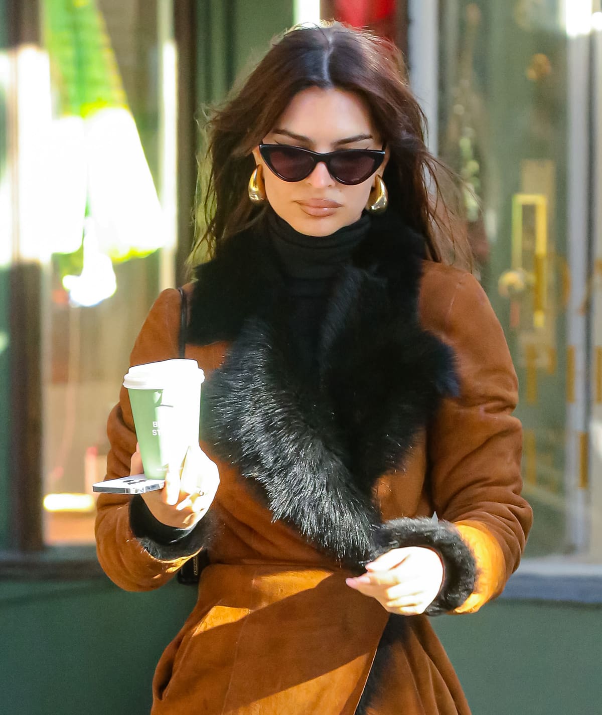 Emily Ratajkowski completes her winter chic ensemble with Chrome Hearts knee-high boots, Pepper Eyewear sunnies, and Bottega Veneta Drop earrings