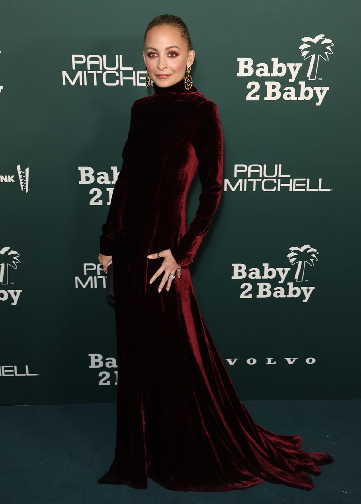 Nicole Richie embraces her signature gothic style in a red velour Alberta Ferretti gown with a high neck, long sleeves, and a floor-sweeping train