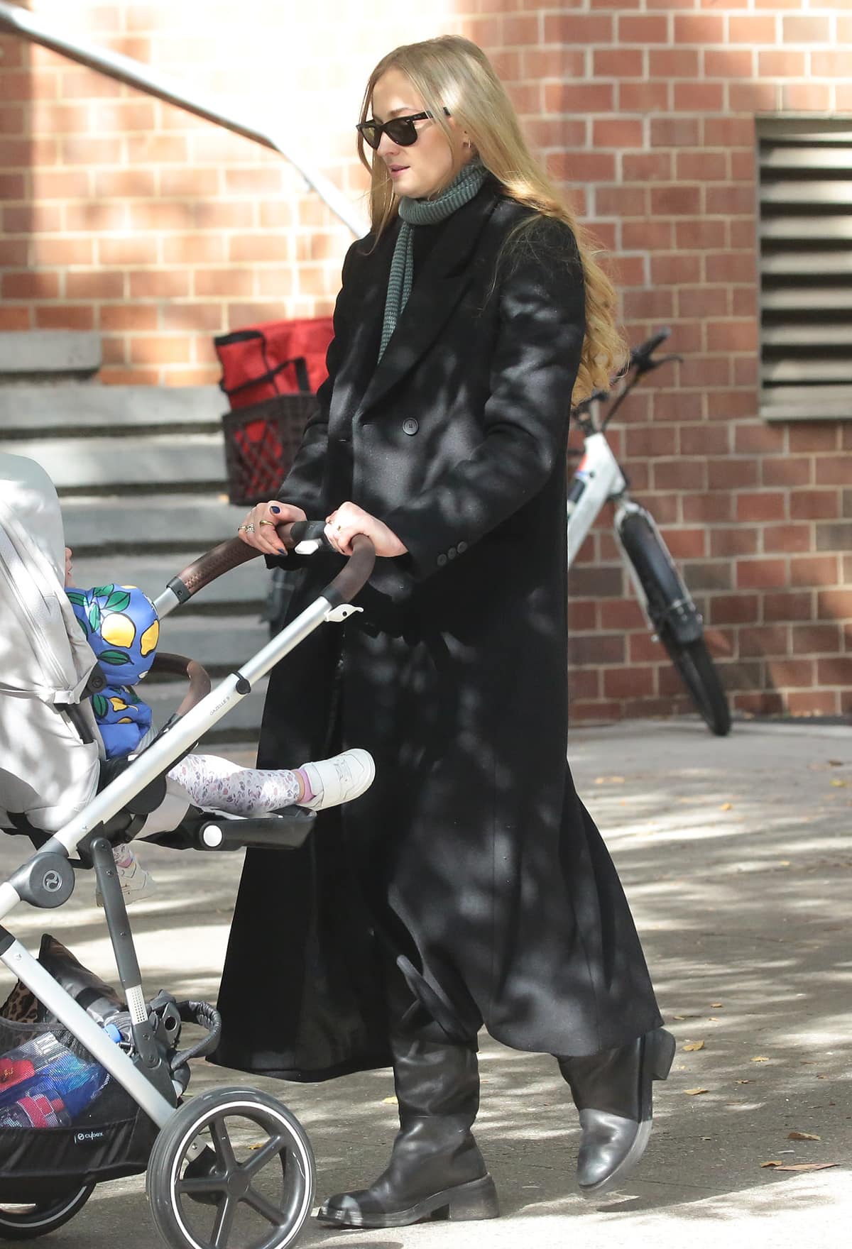 Sophie Turner looks cozy in a coat, scarf, and boots while strolling with her daughters in New York City on November 4, 2023