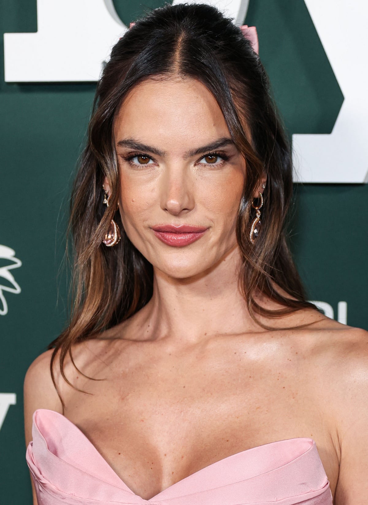 Alessandra Ambrosio’s beauty look consisted of thick eyebrows, soft pink lips, wavy hair accented with a pink bow, and Le Vian jewels