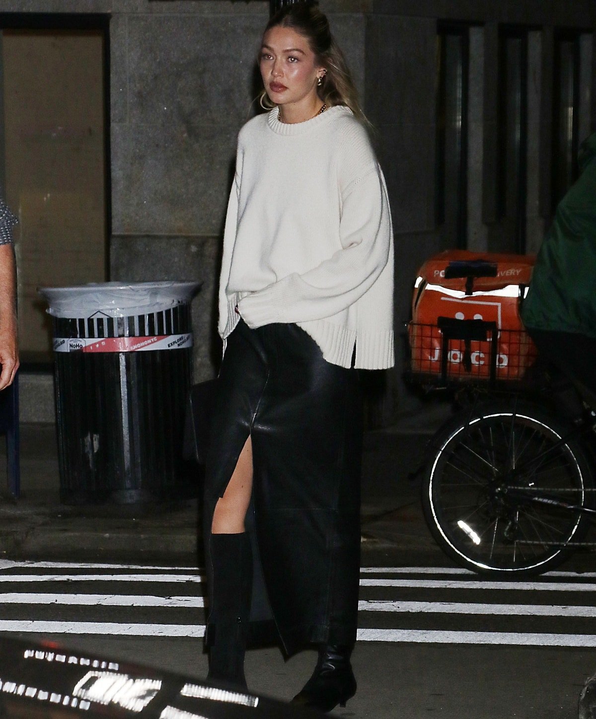 Gigi Hadid celebrating the opening of her first Guest in Residence flagship store in a white sweater with a black leather maxi skirt