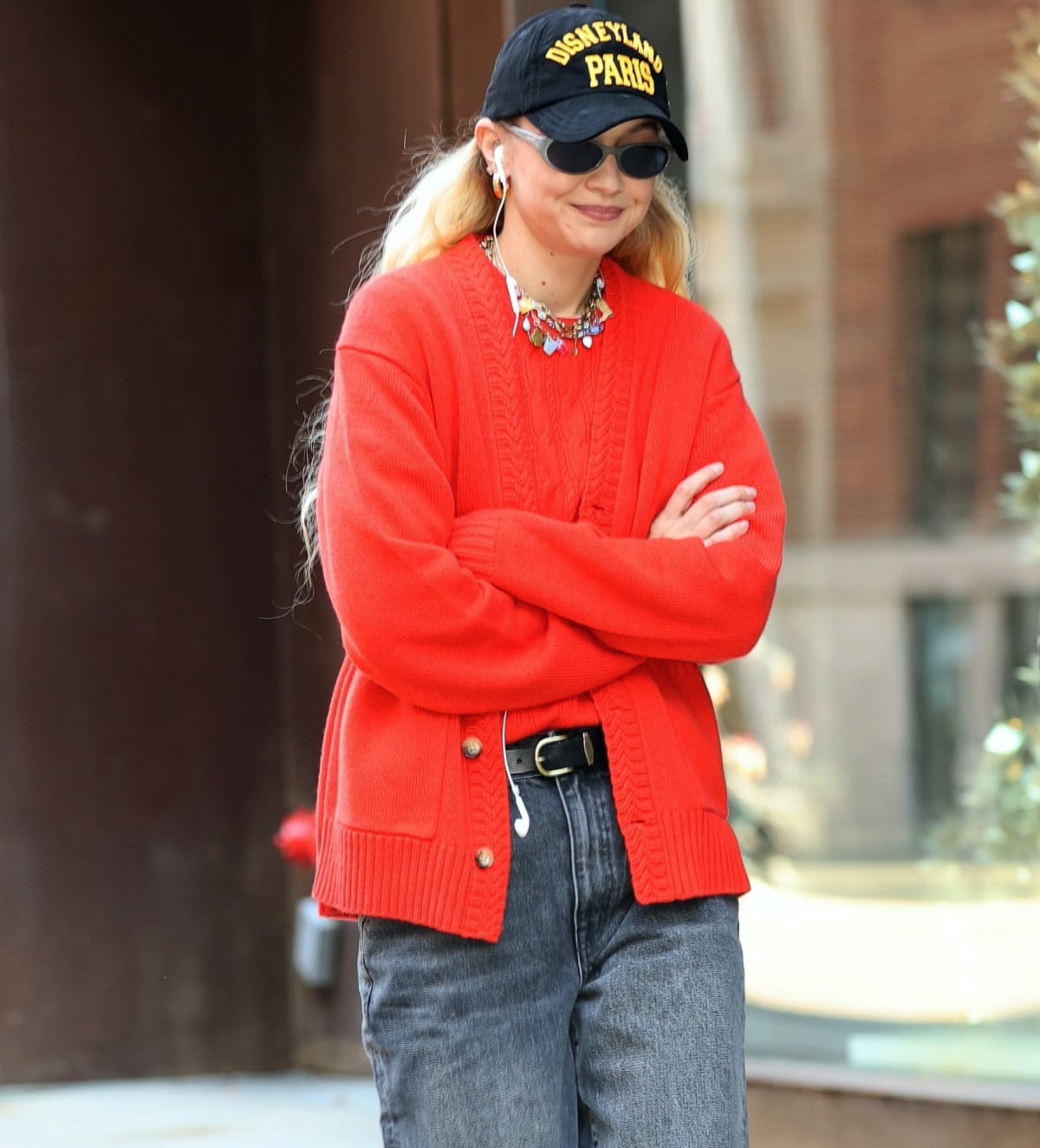 Gigi Hadid styled her look with a Thesagevintage x Haricot Vert “Favorite Things” Charmie necklace, oversized gold hoop earrings, Giorgio Armani 2504 sunglasses, and a Disneyland Paris baseball cap