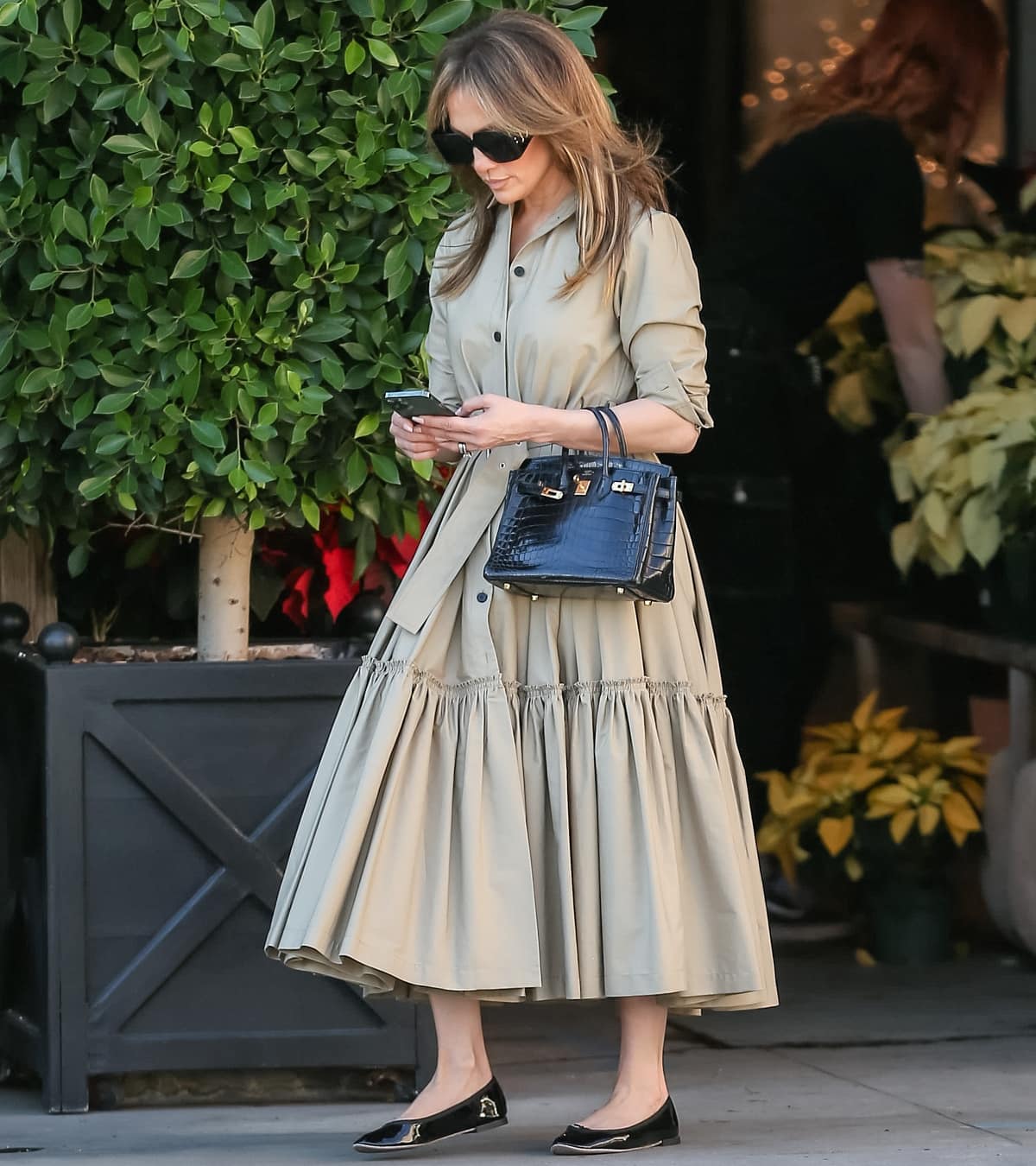 Jennifer Lopez wearing a beige Dior belted Gabardine dress while shopping for plants at the Rolling Greens store in Los Angeles